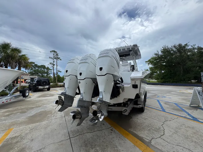  Yacht Photos Pics 2022 Fountain 38 CC boat with triple outboard engines in a parking lot.