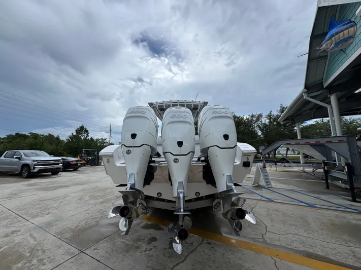  Yacht Photos Pics 2022 Fountain 38 CC boat with four powerful outboard engines in a parking area.