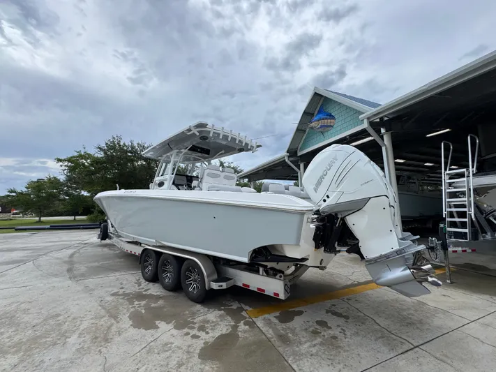  Yacht Photos Pics 2022 Fountain 38 CC boat with Mercury engines on a trailer, parked near a building.