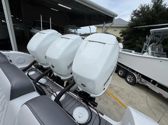  Yacht Photos Pics Triple outboard motors on a 2022 Fountain 38 CC boat in a marina setting.