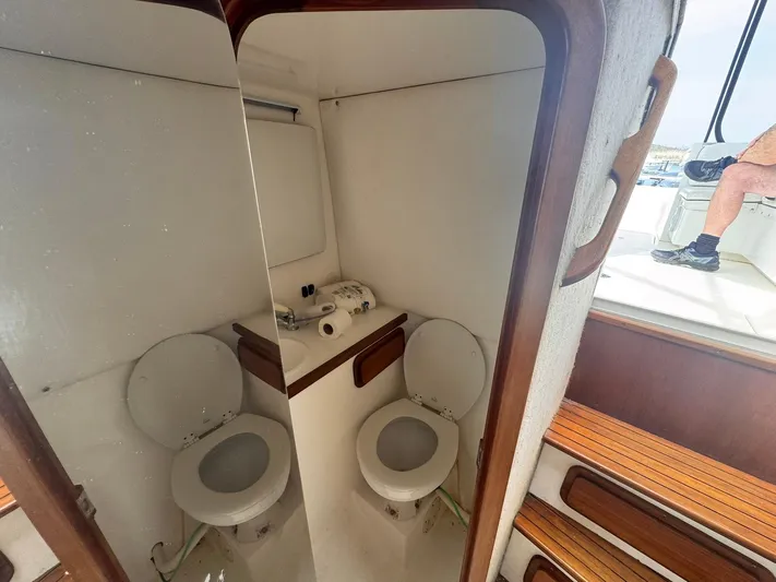  Yacht Photos Pics 1998 Contender 35 Express Side Console boat interior with toilet and wooden steps.