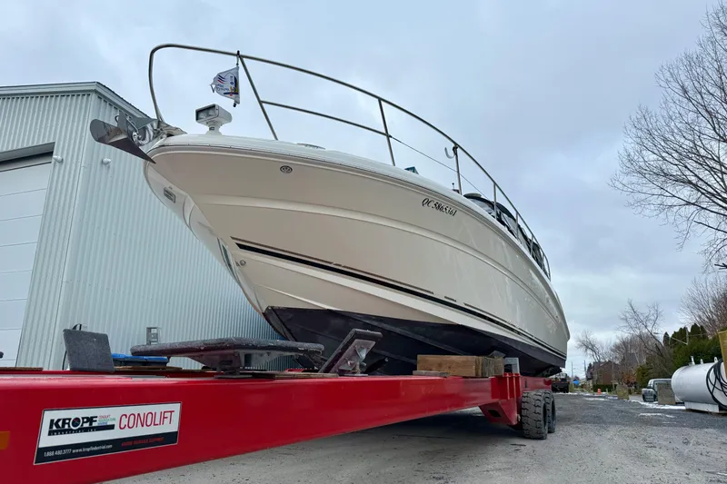  Yacht Photos Pics 2004 Searay 360 Sundancer on red Conolift trailer near industrial building.
