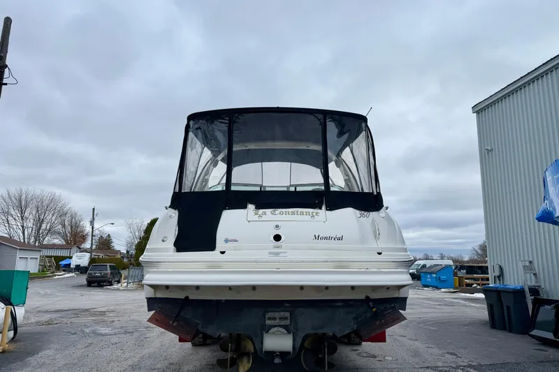 Yacht Photos Pics 2004 Searay 360 Sundancer boat with black canopy, parked outdoors.