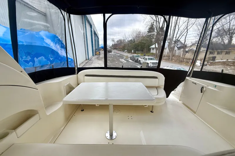  Yacht Photos Pics 2004 Searay 360 Sundancer boat interior with seating and table, docked near a road.