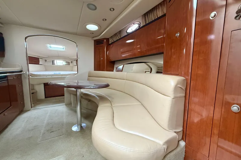  Yacht Photos Pics Interior of 2004 Searay 360 Sundancer yacht with curved seating and wooden cabinetry.