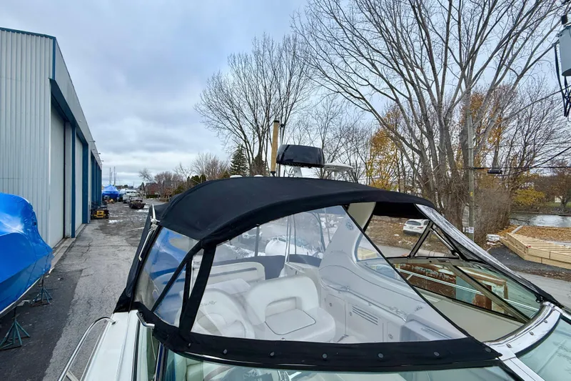  Yacht Photos Pics 2004 Searay 360 Sundancer boat with black canopy, parked near a storage facility.