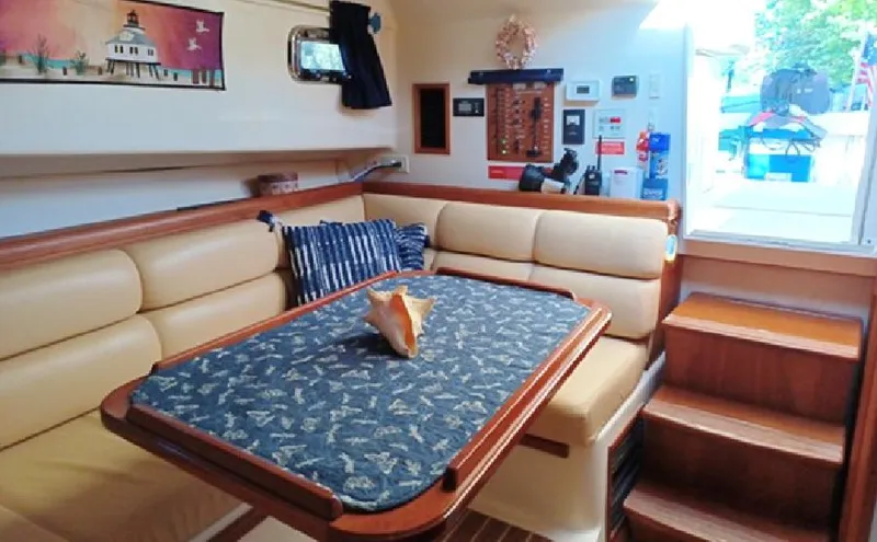 Arcadia Yacht Photos Pics Interior of 2005 Mainship 34 Pilot Rum Runner II with cozy seating and nautical decor.