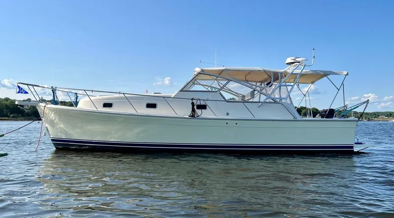 Arcadia Yacht Photos Pics 2005 Mainship 34 Pilot Rum Runner II boat on calm water under clear blue sky.