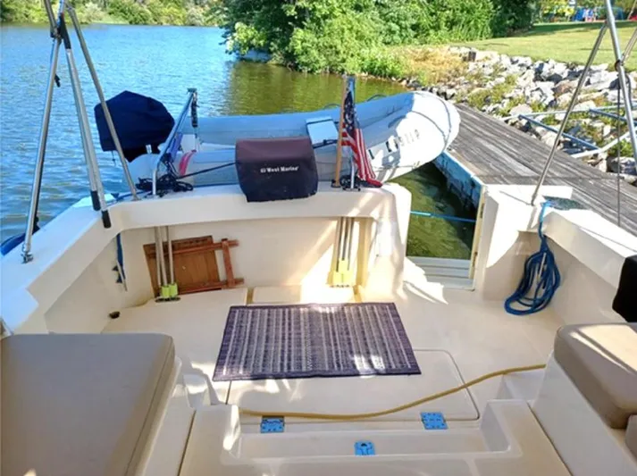 Arcadia Yacht Photos Pics 2005 Mainship 34 Pilot Rum Runner II docked by a serene lake with lush greenery.