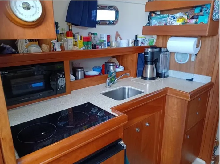 Arcadia Yacht Photos Pics 2005 Mainship 34 Pilot Rum Runner II galley with stove, sink, and storage.