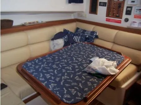 Arcadia Yacht Photos Pics 2005 Mainship 34 Pilot Rum Runner II interior with cushioned seating and nautical-themed table cover.