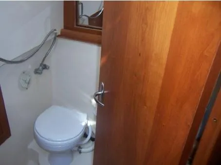 Arcadia Yacht Photos Pics 2005 Mainship 34 Pilot Rum Runner II bathroom with wooden door and compact toilet.