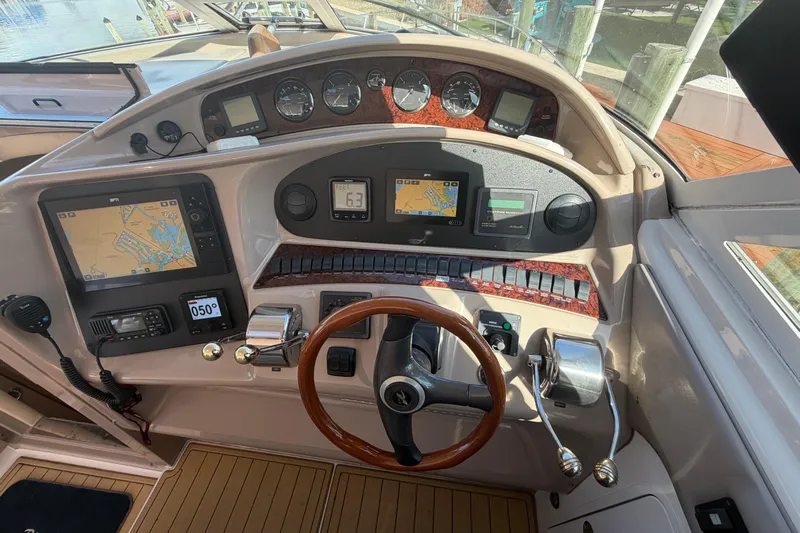  Yacht Photos Pics 2002 Sea Ray 480 Motor Yacht helm with navigation screens and wooden steering wheel.