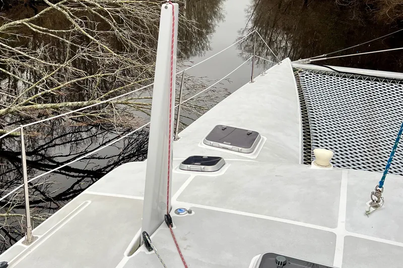 Watermark Yacht Photos Pics Deck of 2003 Chris White Atlantic 42 catamaran with netting and river view.