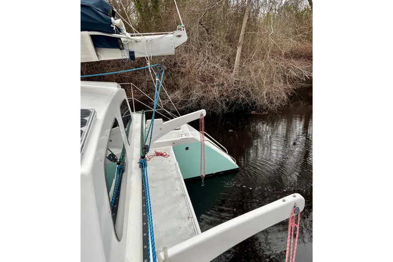 Watermark Yacht Photos Pics 2003 Chris White Atlantic 42 catamaran docked near wooded shoreline.