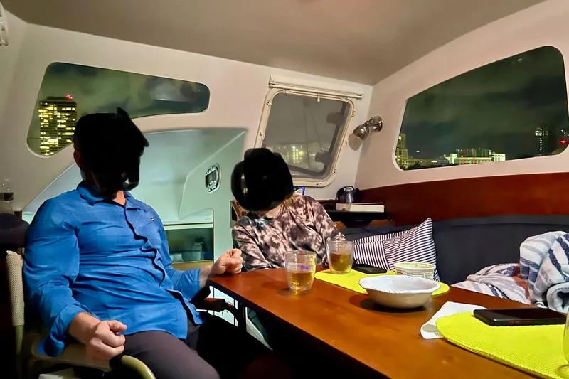 Watermark Yacht Photos Pics Interior of 2003 Chris White Atlantic 42 catamaran with people dining at night.