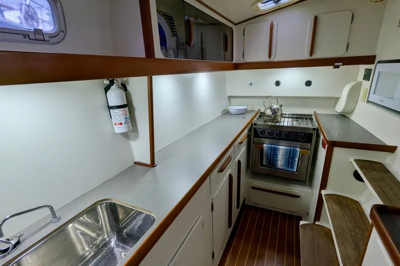 Watermark Yacht Photos Pics Modern galley kitchen in 2003 Chris White Atlantic 42 yacht, featuring stove and sink.