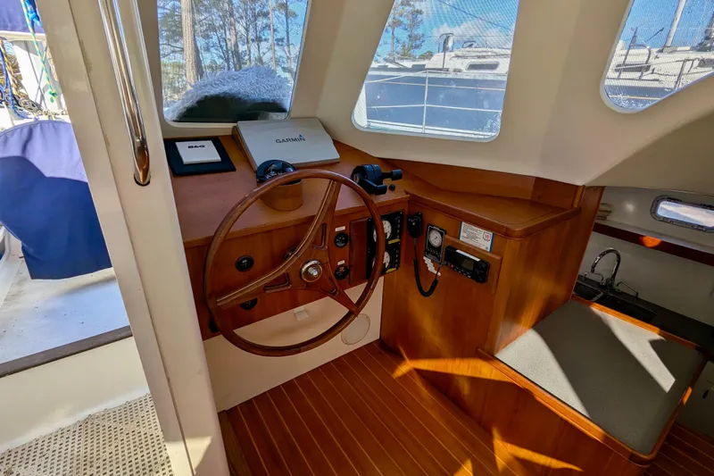 Watermark Yacht Photos Pics Interior helm of 2003 Chris White Atlantic 42 catamaran with wooden steering wheel and navigation equipment.