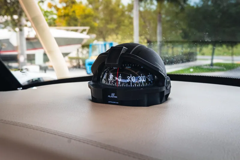  Yacht Photos Pics Compass on 2017 Chris-Craft Catalina 34 dashboard, surrounded by outdoor scenery.