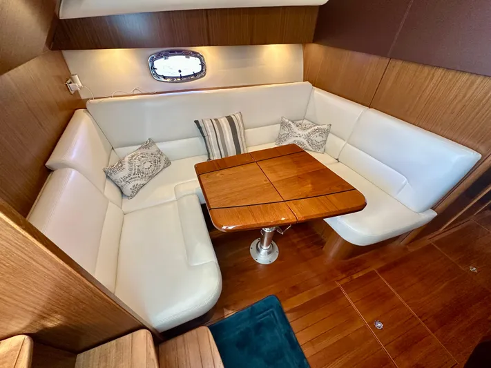  Yacht Photos Pics 2018 Tiara Yachts 4300 Open interior with white leather seating and wooden table.