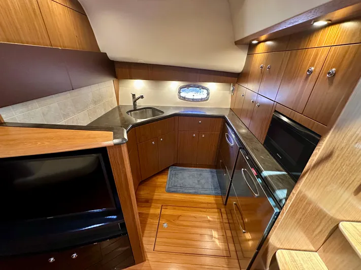  Yacht Photos Pics 2018 Tiara Yachts 4300 Open kitchen with wood cabinetry and modern appliances.