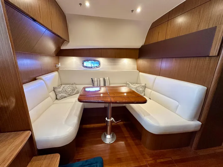  Yacht Photos Pics 2018 Tiara Yachts 4300 Open interior with white seating and wooden table.