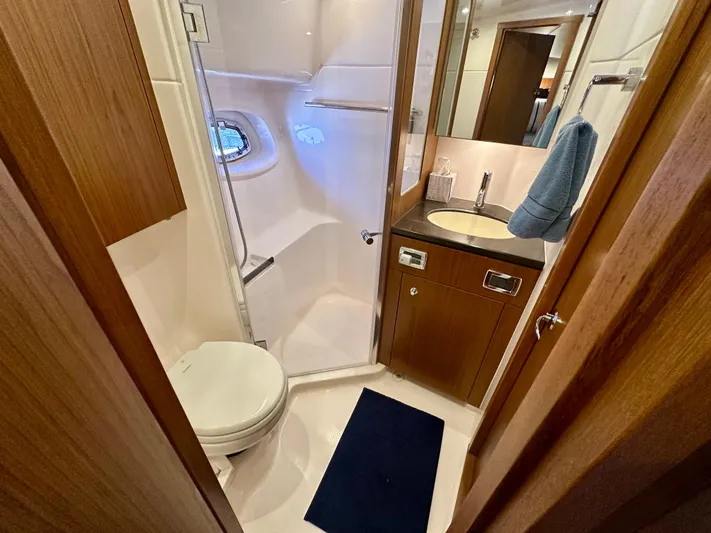  Yacht Photos Pics 2018 Tiara Yachts 4300 Open bathroom with shower, sink, and wooden cabinetry.