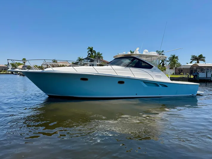  Yacht Photos Pics 2018 Tiara Yachts 4300 Open cruising on a sunny day, surrounded by calm waters and palm trees.