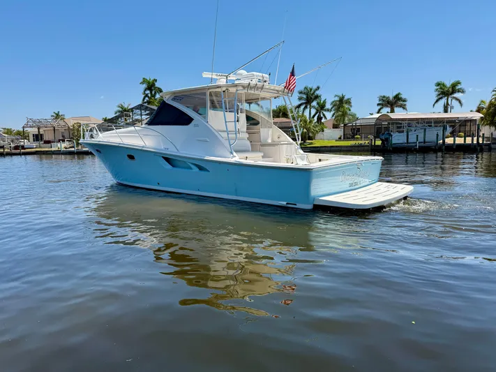  Yacht Photos Pics 2018 Tiara Yachts 4300 Open cruising on a sunny day, surrounded by palm trees.
