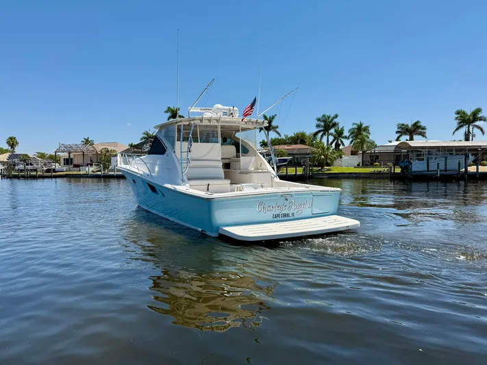  Yacht Photos Pics 2018 Tiara Yachts 4300 Open cruising on a sunny day, surrounded by palm trees.