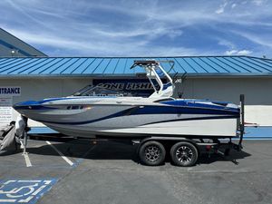 2021 Centurion Fi23 boat on trailer, blue and white design, parked outside a building.
