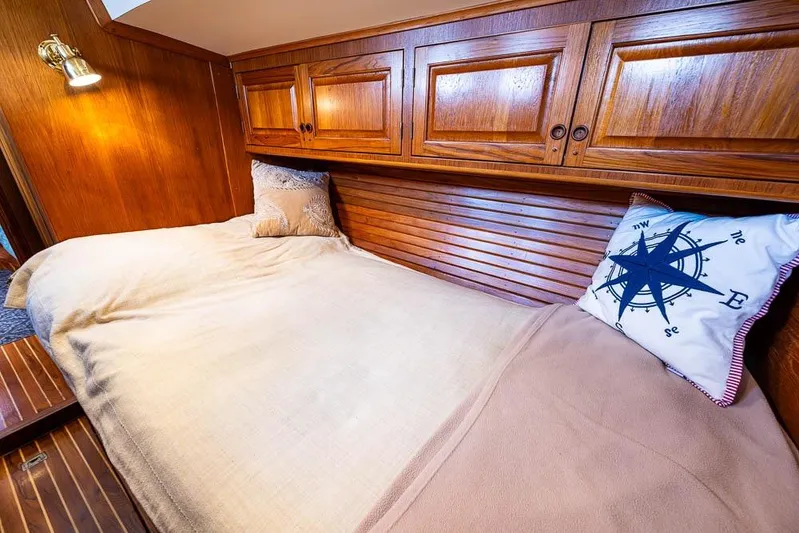 Koh -i -noor Yacht Photos Pics Cozy cabin interior of 1974 C&C 61 Ocean Racer with wooden finish and nautical-themed pillow.