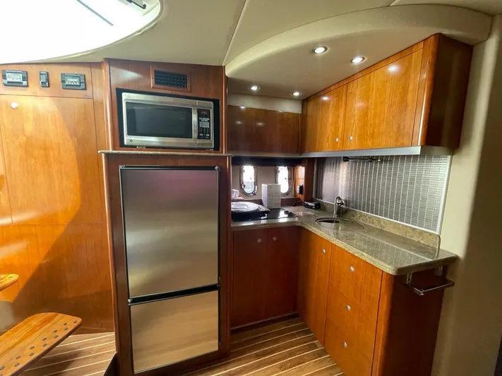  Yacht Photos Pics 2008 Cruisers 390 Sport Coupe kitchen with wood cabinets, stainless appliances, and modern lighting.