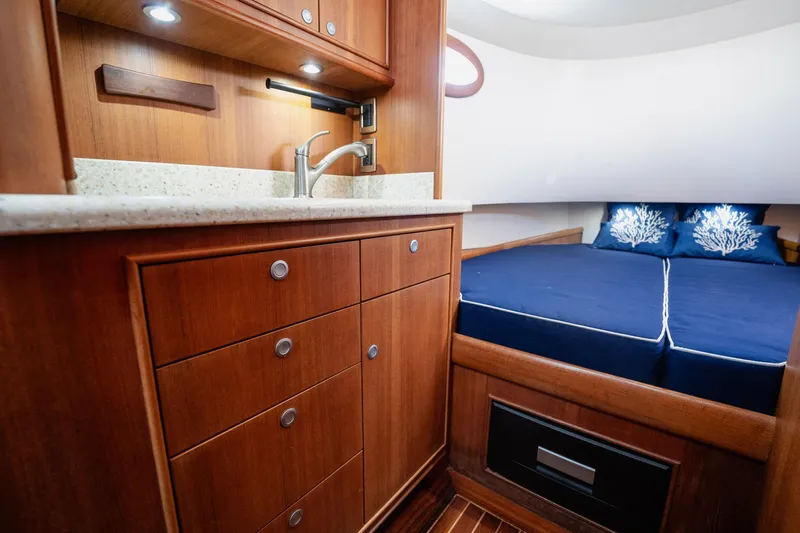 Southern Ground Yacht Photos Pics Luxurious 2015 Winter Custom Yachts W-18 interior with wood cabinetry and cozy sleeping area.