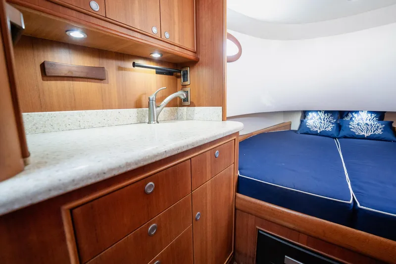 Southern Ground Yacht Photos Pics Luxurious 2015 Winter Custom Yachts W-18 interior with wooden cabinetry and cozy bedding.