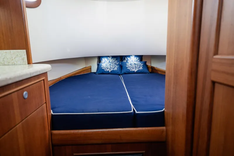 Southern Ground Yacht Photos Pics Cozy cabin interior of 2015 Winter Custom Yachts W-18 with blue bedding and wooden finish.