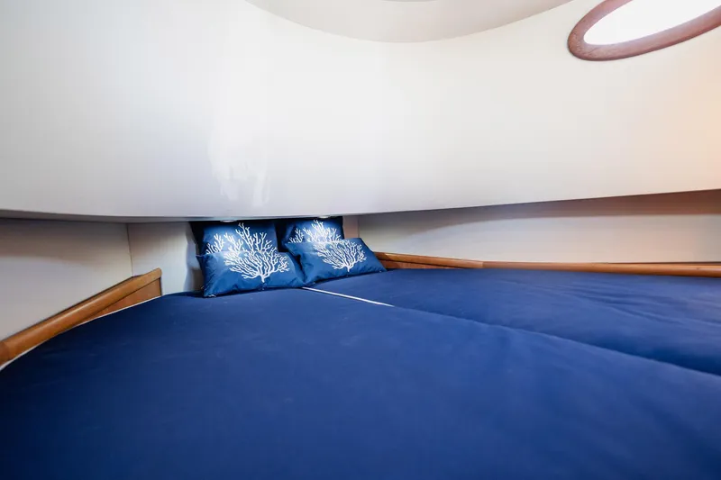 Southern Ground Yacht Photos Pics Luxurious cabin interior of 2015 Winter Custom Yachts W-18 with blue bedding and decorative pillows.