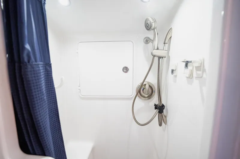 Southern Ground Yacht Photos Pics Shower area in 2015 Winter Custom Yachts W-18, featuring modern fixtures and blue curtain.