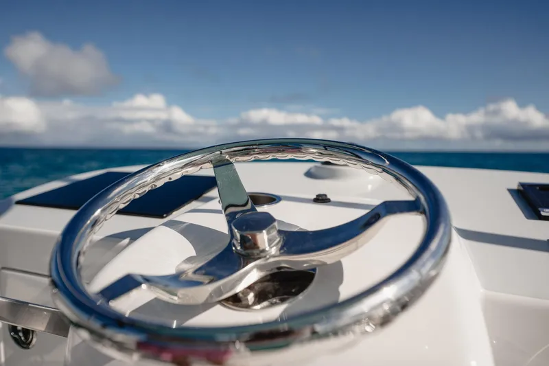 Southern Ground Yacht Photos Pics Steering wheel of 2015 Winter Custom Yachts W-18 against ocean backdrop.