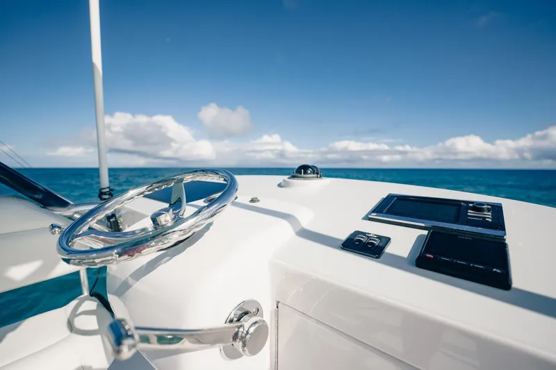 Southern Ground Yacht Photos Pics Steering wheel and controls of 2015 Winter Custom Yachts W-18 against ocean backdrop.