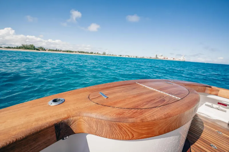 Southern Ground Yacht Photos Pics 2015 Winter Custom Yachts W-18 on blue ocean, wooden deck detail, clear sky.