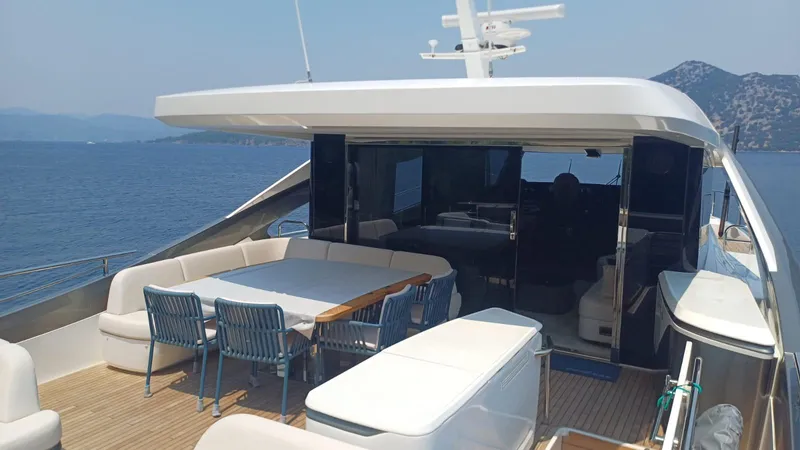  Yacht Photos Pics Luxurious 2024 Princess X80 yacht deck with seating, overlooking serene ocean and mountains.