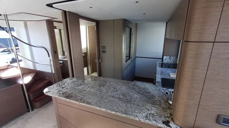  Yacht Photos Pics Luxurious interior of 2024 Princess X80 yacht featuring modern kitchen and elegant staircase.