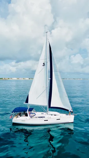 “imagine That” Yacht Photos Pics 2015 Beneteau Oceanis 45 sailing on calm blue waters under a cloudy sky.