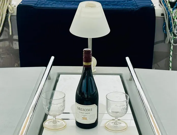 “imagine That” Yacht Photos Pics Bottle of Meiomi Pinot Noir with glasses on Beneteau Oceanis 45 yacht table.