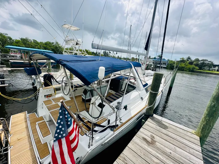 “imagine That” Yacht Photos Pics 2015 Beneteau Oceanis 45 sailboat docked, featuring blue canopy and American flag.