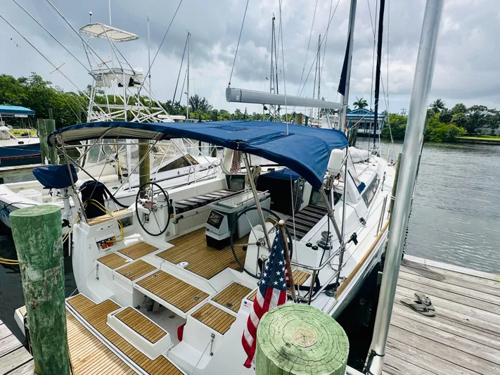 “imagine That” Yacht Photos Pics 2015 Beneteau Oceanis 45 sailboat docked, featuring a blue canopy and wooden deck.