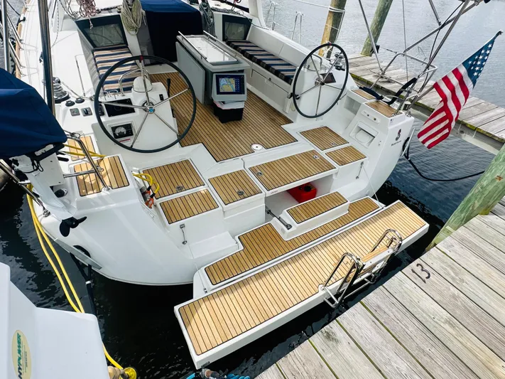 “imagine That” Yacht Photos Pics 2015 Beneteau Oceanis 45 sailboat with dual steering wheels, docked with American flag.