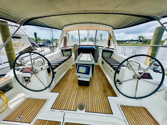 “imagine That” Yacht Photos Pics Cockpit of 2015 Beneteau Oceanis 45 sailboat with dual steering wheels and teak flooring.