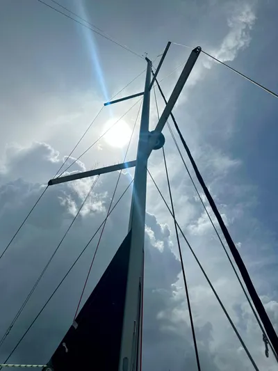 “imagine That” Yacht Photos Pics Mast of 2015 Beneteau Oceanis 45 sailboat against cloudy sky and sun.